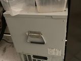 two bins on top of a freezer on the floor
