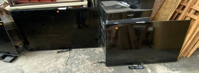 two black refrigerators sitting next to each other in a room