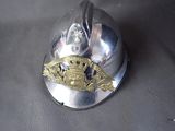 un casque de pompier en argent orné d'un insigne en or