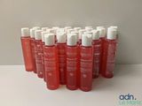 plusieurs bouteilles contenant un liquide rouge posées sur une table blanche