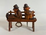two figurines of two men sitting on a bench