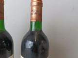 two bottles of wine sitting next to each other on a table