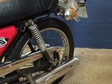 a red motorcycle parked in a garage with a blue wall