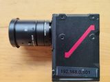 un appareil photo noir sur lequel figure une flèche rouge