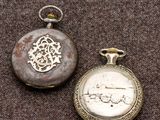 deux montres de poche en argent posées sur une surface marron
