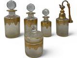 four glass bottles with gold and silver designs on them