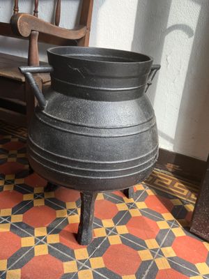 a black pot sitting on top of a wooden chair