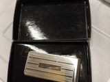 un porte-billets en argent dans un coffret noir posé sur une table