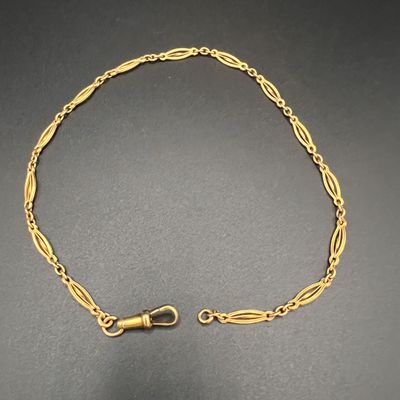 un gros plan sur un bracelet en chaîne dorée muni d'un fermoir
