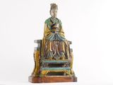 a statue of a man sitting on top of a chair