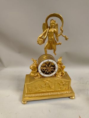 une horloge en or surmontée d'une statue