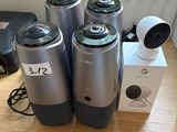 four silver and black speakers sitting on top of a wooden table