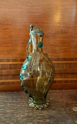 un vase en verre posé sur une table, avec un mur en bois en arrière-plan