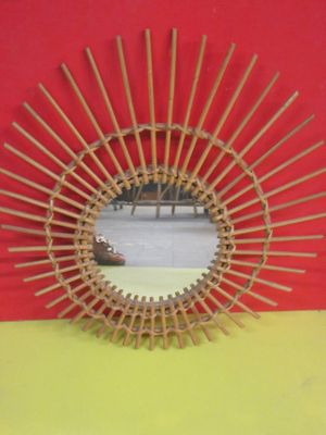 une photo d'un miroir fabriqué à partir de tiges de bambou