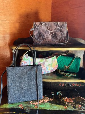two bags and a purse sitting on a shelf