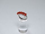 a close up of a ring with red beads on it