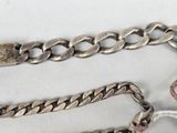 three silver chains are laying next to each other on a white surface