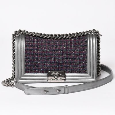 a small silver purse with a chain strap on a white background