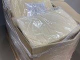 des cartons contenant des matelas emballés dans du plastique, posés sur une palette en bois