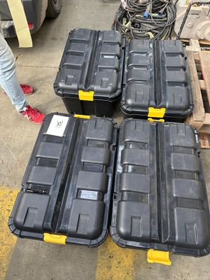 de nombreuses boîtes noires posées par terre à côté d'une palette