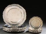 two silver plates and a silver plate on a black background