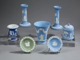 plusieurs vases et assiettes bleus et blancs exposés sur un support gris