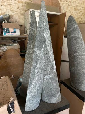 three stone cones sitting on a table in a room