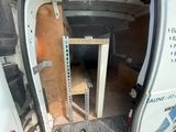 une camionnette blanche avec un banc en bois à l'arrière