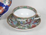 a cup and saucer sitting on a table next to a plate