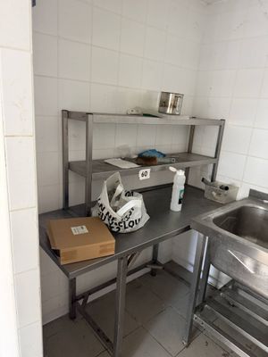 une petite cuisine équipée d'un évier et d'un plan de travail en métal