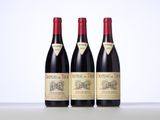 three bottles of red wine sitting on top of a table