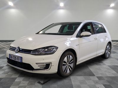 une Volkswagen e-Golf blanche garée sur un sol à damier