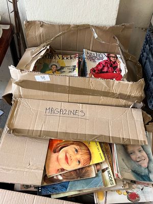 Des cartons de magazines sont empilés les uns sur les autres par terre