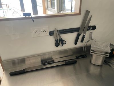 une photo d'un plan de travail de cuisine avec des couteaux et une casserole