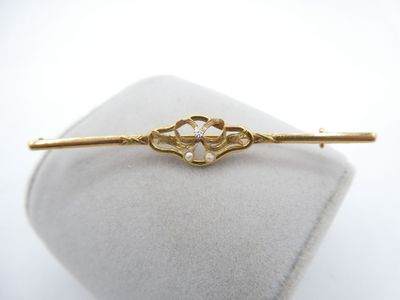 a close up of a gold hair pin with pearls on it