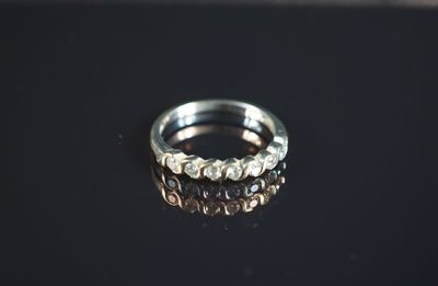 gros plan d'une bague en argent sur une surface noire