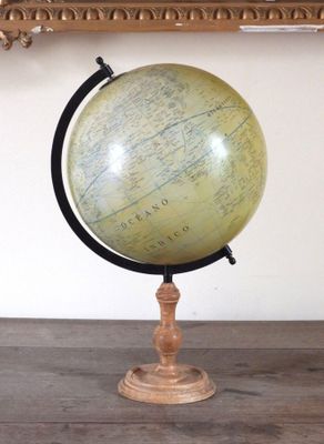 un vieux globe terrestre posé sur une table en bois, à côté d'un miroir