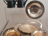 une vitrine en verre dans laquelle sont exposés des assiettes et des tasses en argent
