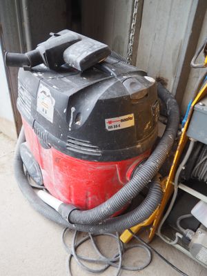 un aspirateur rouge et noir posé à côté d'une porte de garage
