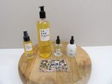 a wooden tray with a bottle of liquid, a bottle of lotion, and a bottle of lotion on it