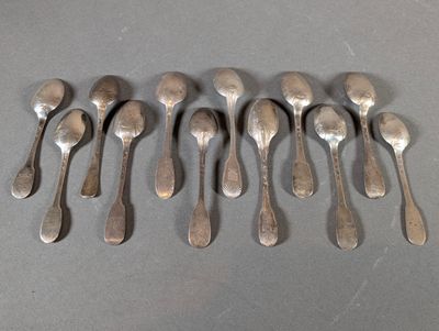 six silver spoons are arranged in a row on a table