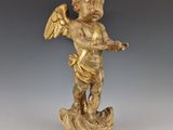 une image représentant une statue d'ange ailé posé sur un rocher