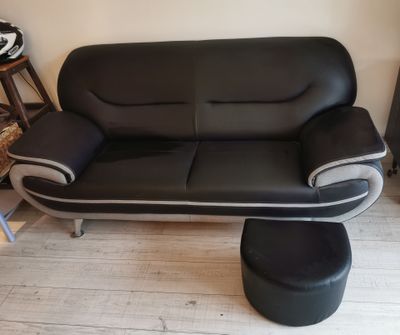 a black and white leather couch and ottoman in a living room