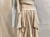 an image of a mannequin wearing a beige dress on a mannequin stand