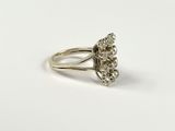 a close up of a diamond ring on a white surface