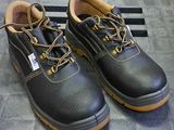 pair of black leather work shoes with yellow laces on the sole