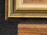 an image of a painting on a wooden easel next to a painting on a wall