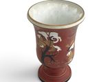 a red vase with a bird design on it