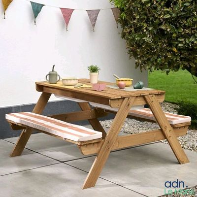 une table de pique-nique avec deux bancs et une plante en pot posée dessus