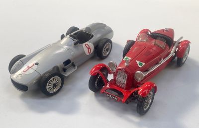 two toy cars sitting next to each other on a white surface
